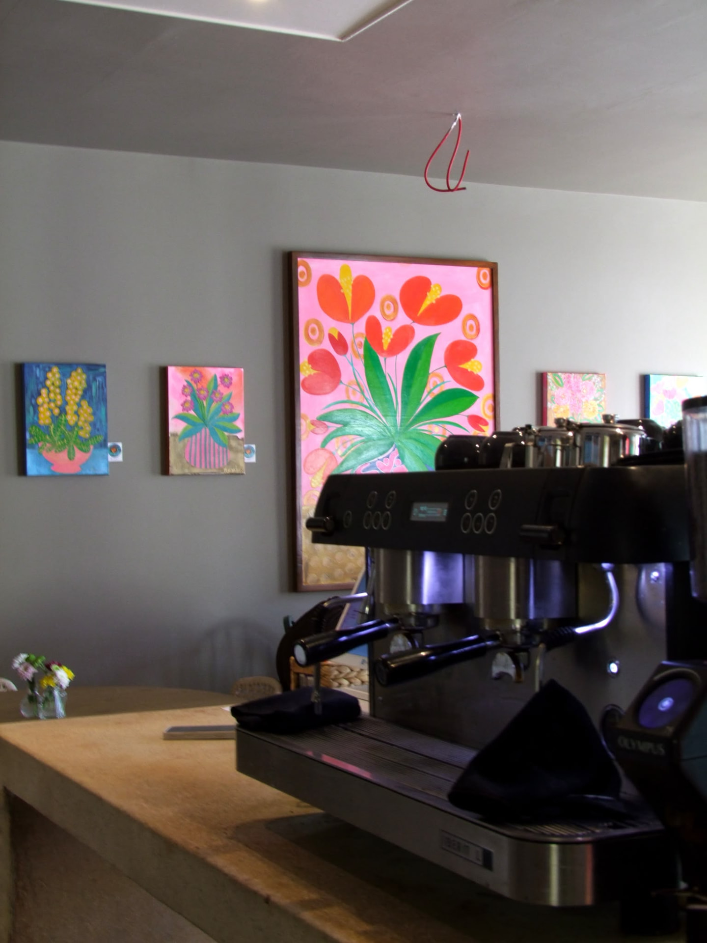 The espresso machine on the counter at Cupán C with local paintings on the wall behind