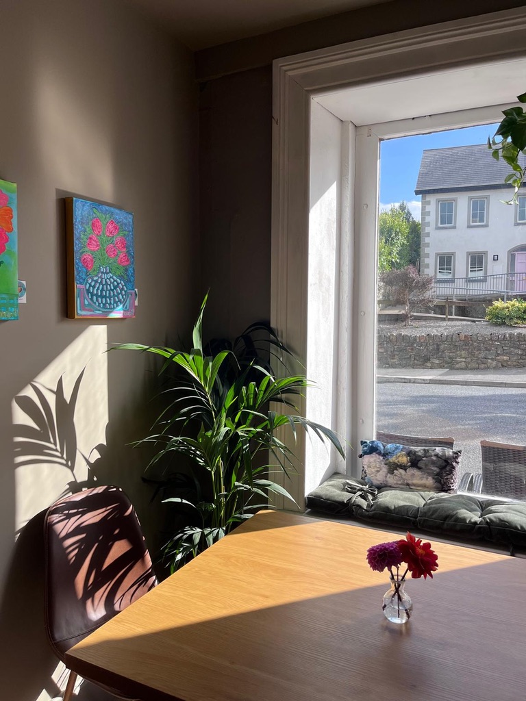 A sunny window table inside Cupán C looking out onto Bunmahon village